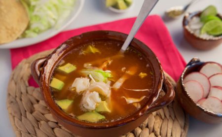 Pozole Rojo de Puerco acompañado de muchos ingredientes