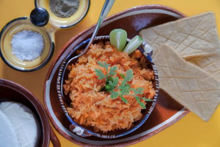 Arroz Rojo con limones y galletas saladas en un plato de barro