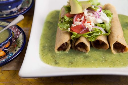 Tacos Dorados de Carne sobre salsa verde